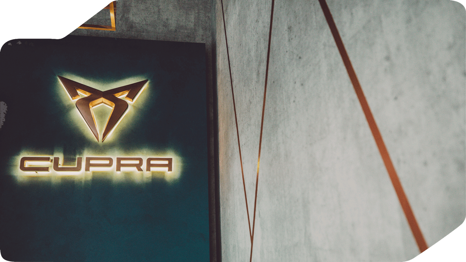 Wanddetail im Innenbereich der CUPRA Garage Hamburg mit beleuchtetem CUPRA Logo